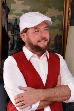 Mark Cummings as John McVie in red vest and white cap