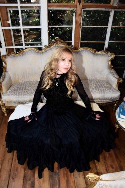 Lisa McCormick as Stevie Nicks in front of couch